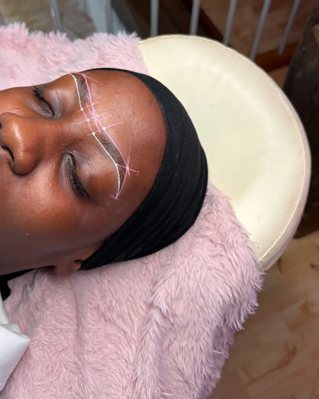 Mapping tracé en blanc sur le sourcil d'une cliente allongée
